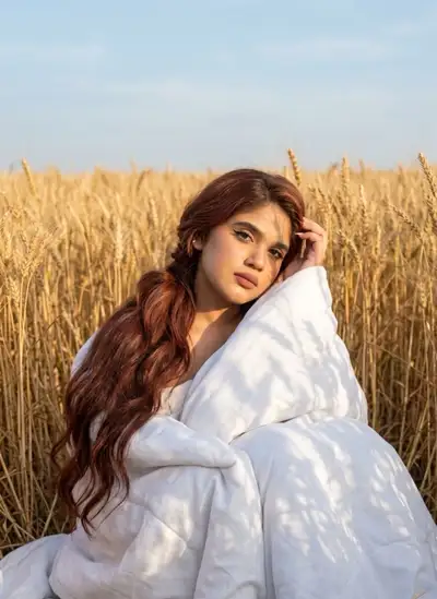 Photo éditoriale d'une femme enveloppée dans une couverture dans un champ de blé