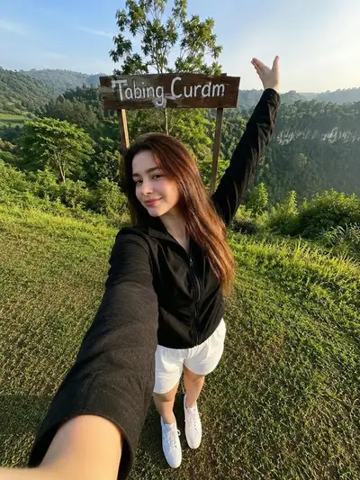 Selfie de viagem que preserva a identidade em uma colina verde