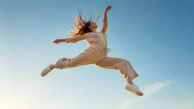 Woman mid-air jump photo in linen jumpsuit against clear sky