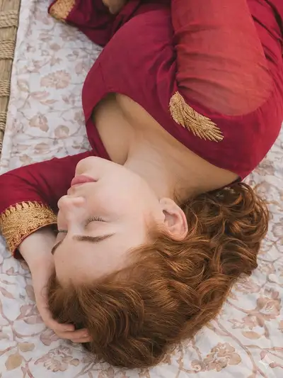 High-Angle Close-Up of Woman on Woven Bed
