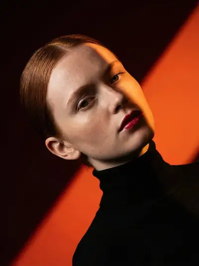 High-fashion editorial portrait with a dramatic diagonal shadow