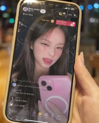 ひび割れた画面のスマホに映る韓国のTikTokライブ、フルUI付き
