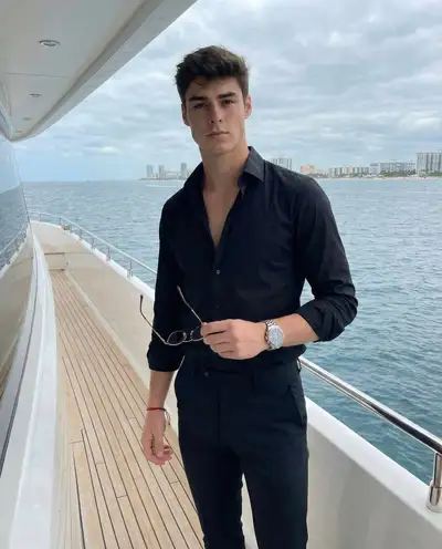 Man on a boat deck with a seaside cityscape backdrop