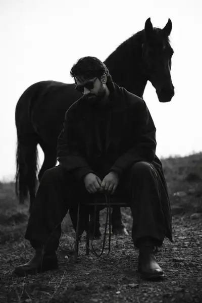 Retrato melancólico en blanco y negro con un caballo