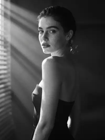 Cinematic black and white portrait with sunlight through blinds