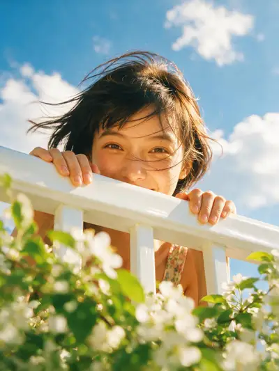 Low angle balcony portrait, woman peeking over white railing