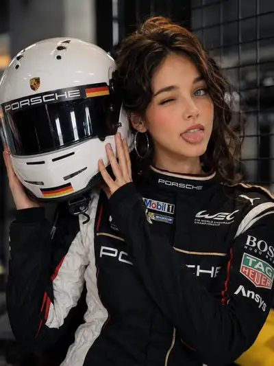 レーシングヘルメットを手にした遊び心あふれるモータースポーツドライバーのポートレート