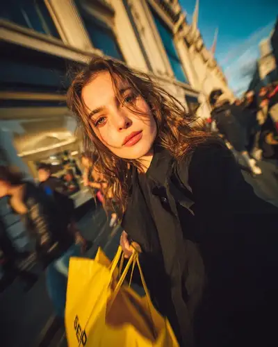 Cinematic golden hour street portrait with shopping bags