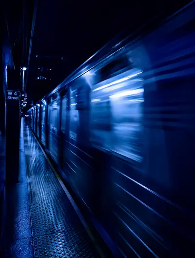 Blurred subway train at night in deep blue tones