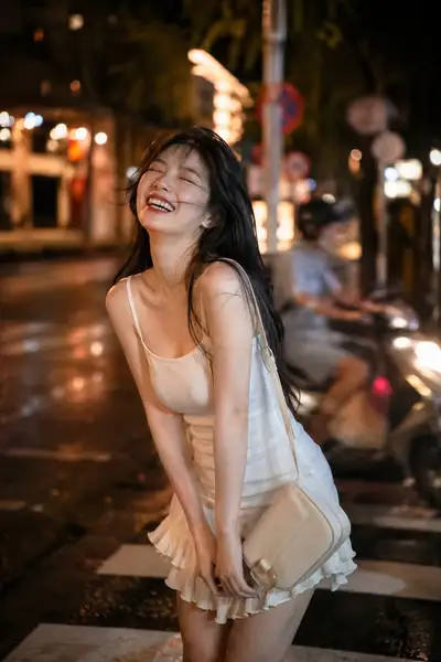Photo de rue spontanée d'une femme riant la nuit