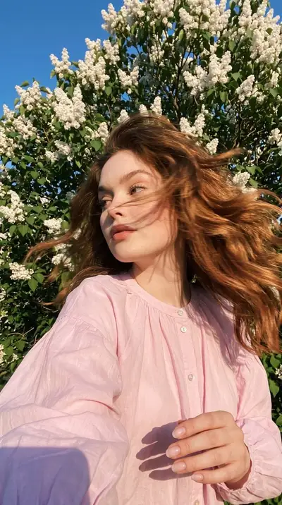 Selfie espontánea que preserva la identidad bajo un lilo en flor