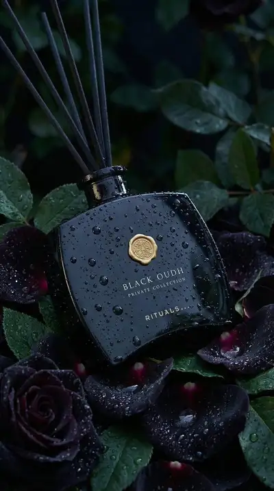 Moody luxury reed diffuser product shot among black roses