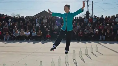 Impossible Bottle Walk: acrobat balances on glass bottles