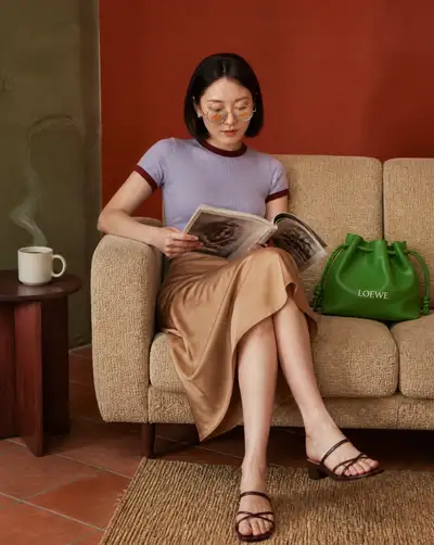 Editorial portrait with a designer bag and goldfish-lens glasses