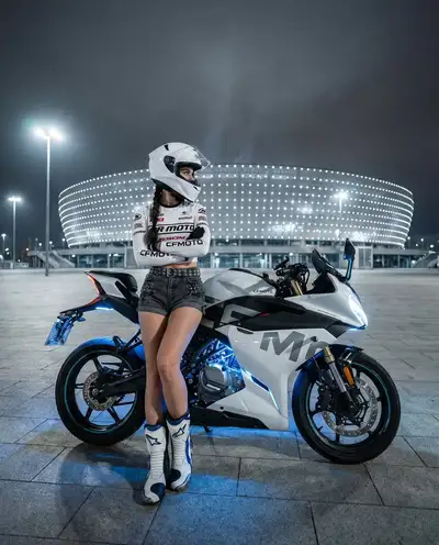 Female motorcyclist portrait leaning on a sportbike at night