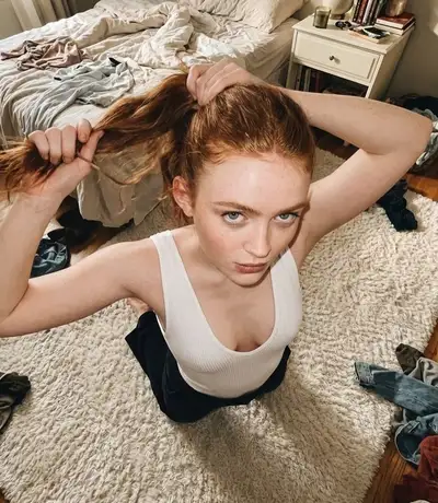 Redhead Tying Ponytail in Messy Bedroom
