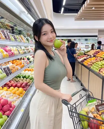 Frau beim Einkaufen in der Obst- und Gemüseabteilung eines modernen Supermarkts