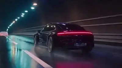 Publicité cinématographique Porsche Taycan sous la pluie nocturne