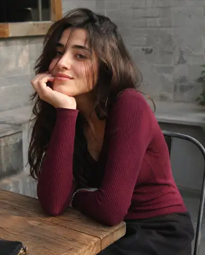 Portrait en extérieur, menton posé sur la main, sourire doux