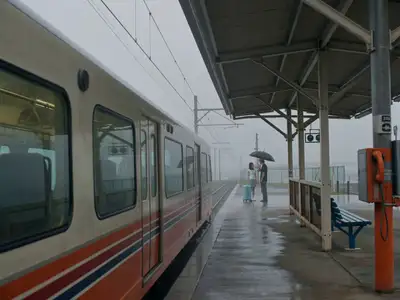 Escena de despedida costera bajo la lluvia con estética de película de los 90
