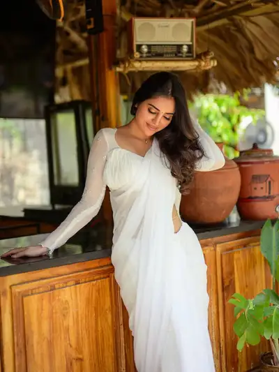 Elegant Indian Woman in White Saree at Rustic Cafe