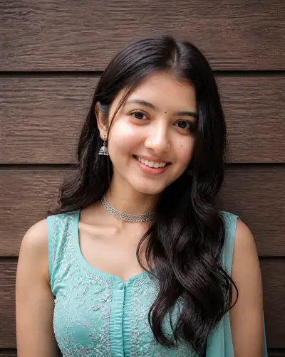 Turquoise embroidered top portrait against wood-grain wall