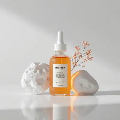 Orange serum bottle with amber rim light between sculptural rocks