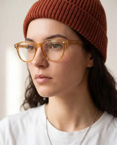 Close-up portrait in amber glasses and a ribbed beanie