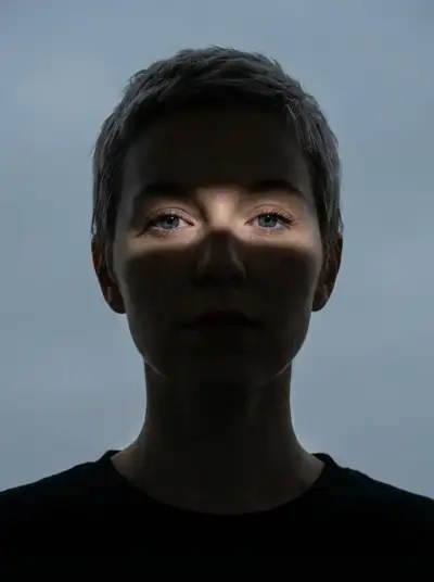 Moody high-contrast portrait with a single band of light
