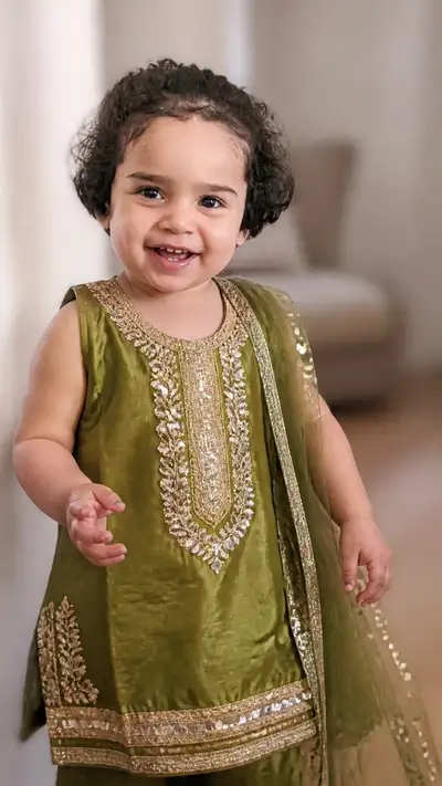 Portrait of a toddler in olive-green embroidered traditional tunic