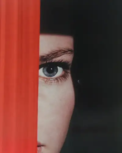Woman's Eye Behind Red Curtain