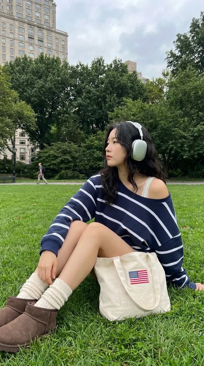 A medium full-body shot of a trendy 24-year-old Korean woman relaxing on a lush