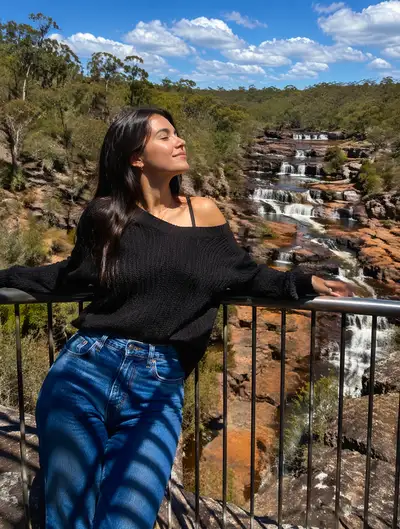 Woman leaning on a railing over the Australian bush