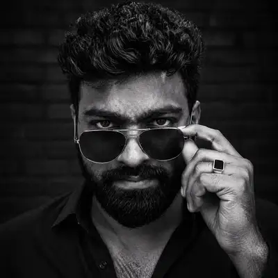 Moody black and white portrait of a man lowering sunglasses