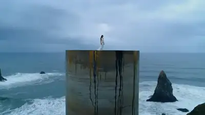 Woman on Golden Concrete Tower Over Stormy Ocean